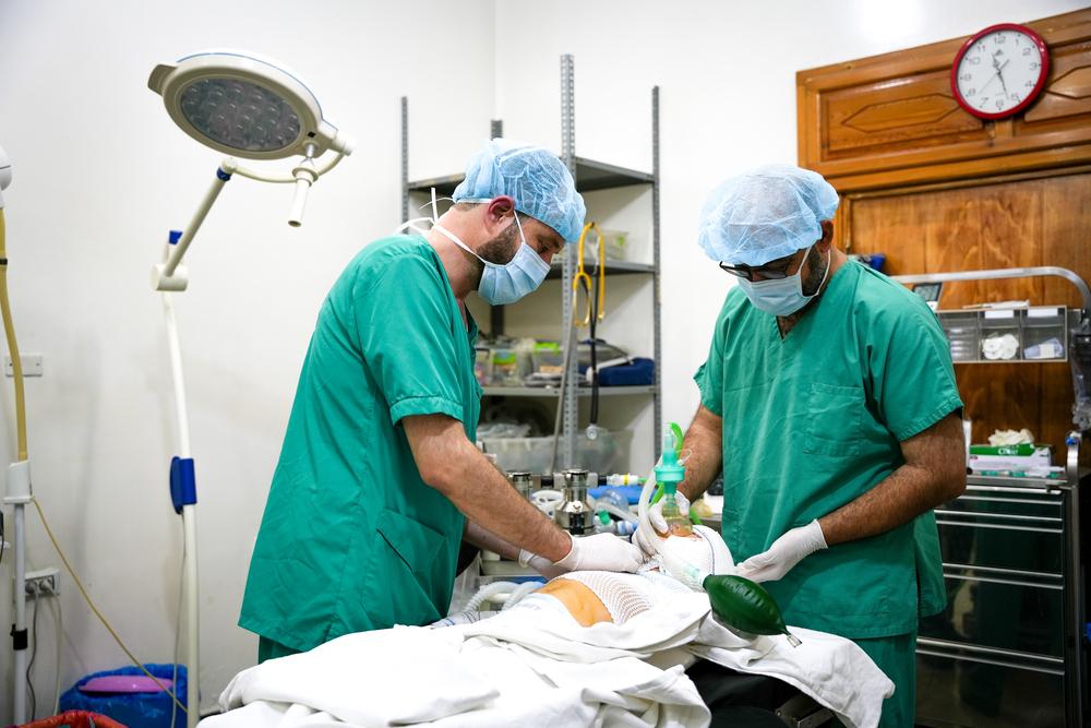 The nursing team is performing the final medical procedures before removing the child from the operating room after undergoing surgery. Syria, October 2023. © Abdulrahman Sadeq