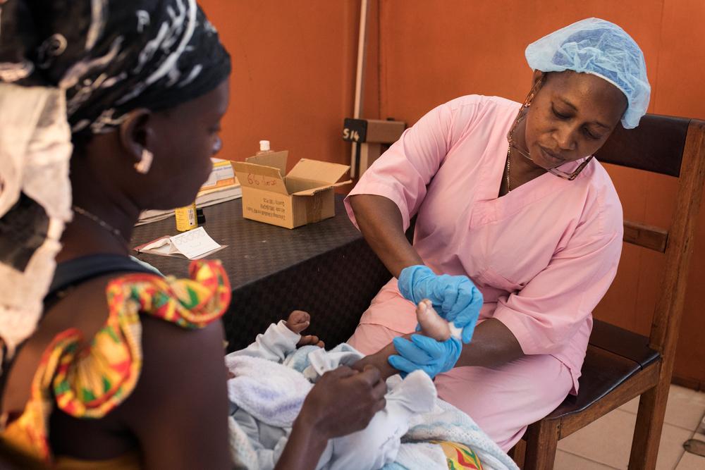 a Guinean Health Ministry midwife performs an Early Infant Diagnosis (EID) test on a newly born infant (12 weeks old) who was born to an HIV positive mother. Guinea, 2018. © Albert Masias/MSF  