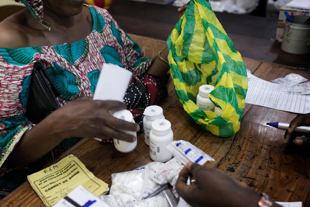 A patient collects her six months of antiretroviral therapy (ART) and related drugs at MSF-supported pharmacy as part of her six-monthly R6M consultation at the MSF-supported HIV outpatient department at Matam health centre, Conakry. Guinea, 2018. © Albert Masias/MSF