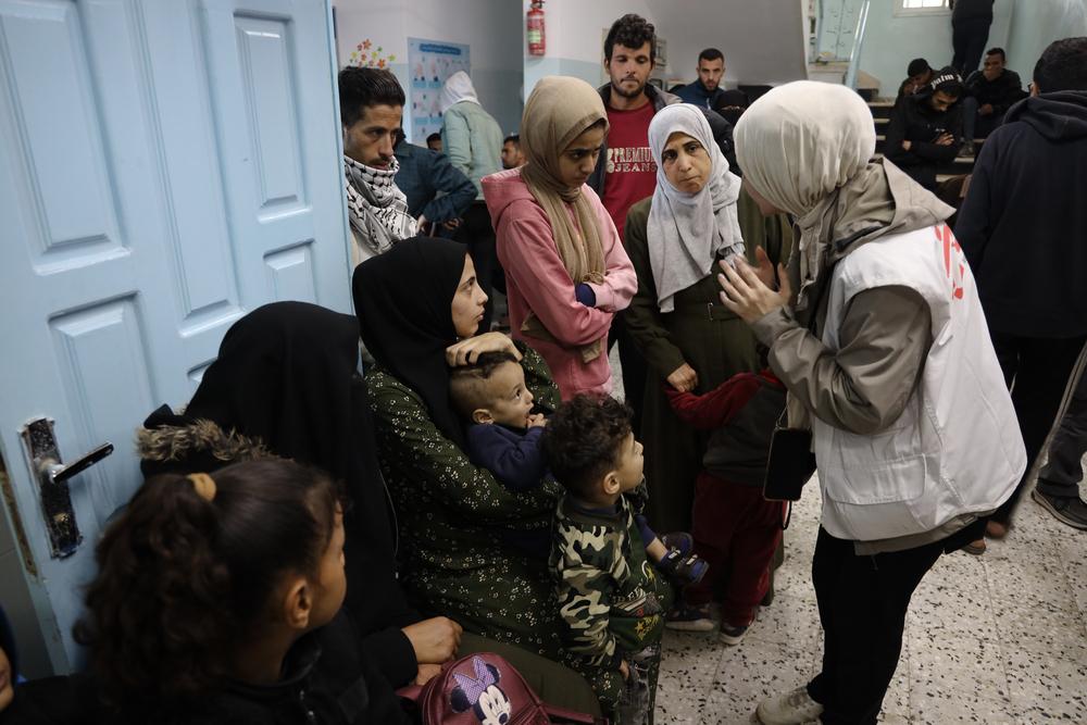 Medical activity manager talking to patients at the Al-Shaboura clinic, Rafah. Palestinian Territories, December 2023. © Mohammad Abed