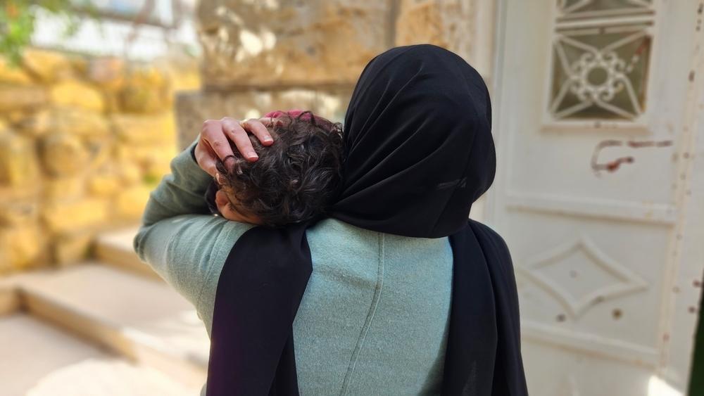 A Palestinian woman holds tight her daughter in her arms. West Bank, Palestinian Territories, December 2023. © Laora Vigourt/MSF