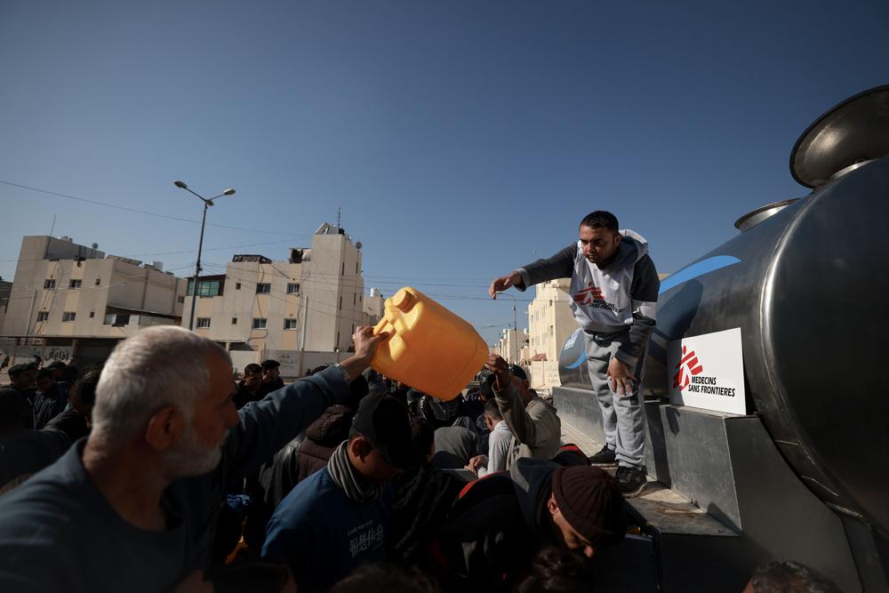 A Doctors Without Borders water and sanitation staff, oversees a water distribution for displaced people in the southern Gaza town of Rafah’s Saudi neighborhood. Palestinian Territories, February 2024. © Mohammed Abed