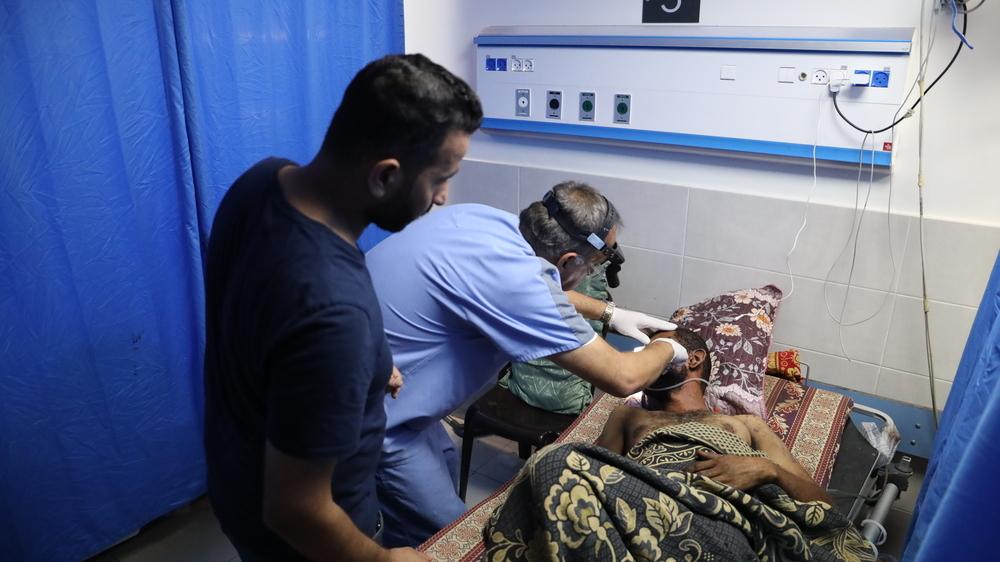 Doctors Without Borders (MSF) staff treats a patient with a facial injury at Al Shifa hospital in Gaza City. Palestinian Territories, October 2023. © Mohammad Masri