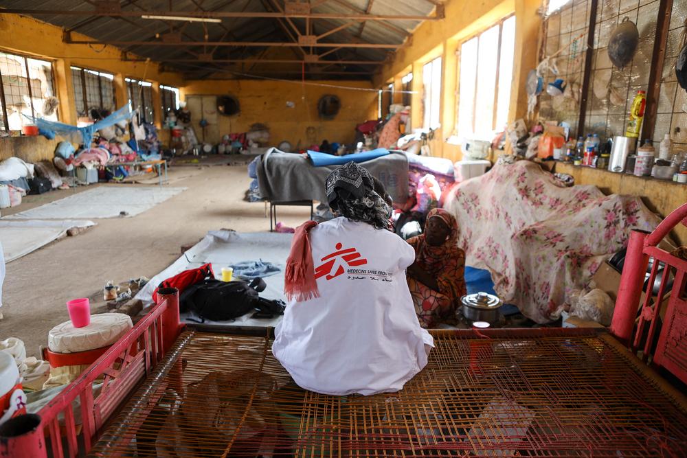 A Doctors Without Borders staff member speaks with a patient in Fadasi Camp in Wad Madani. Sudan, December 2023. © Fais Abubakr