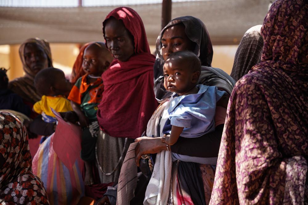 Mothers and children wait in a queue at Doctors Without Borders clinic in Zamzam camp. Sudan, February 2024. © Mohamed Zakaria 