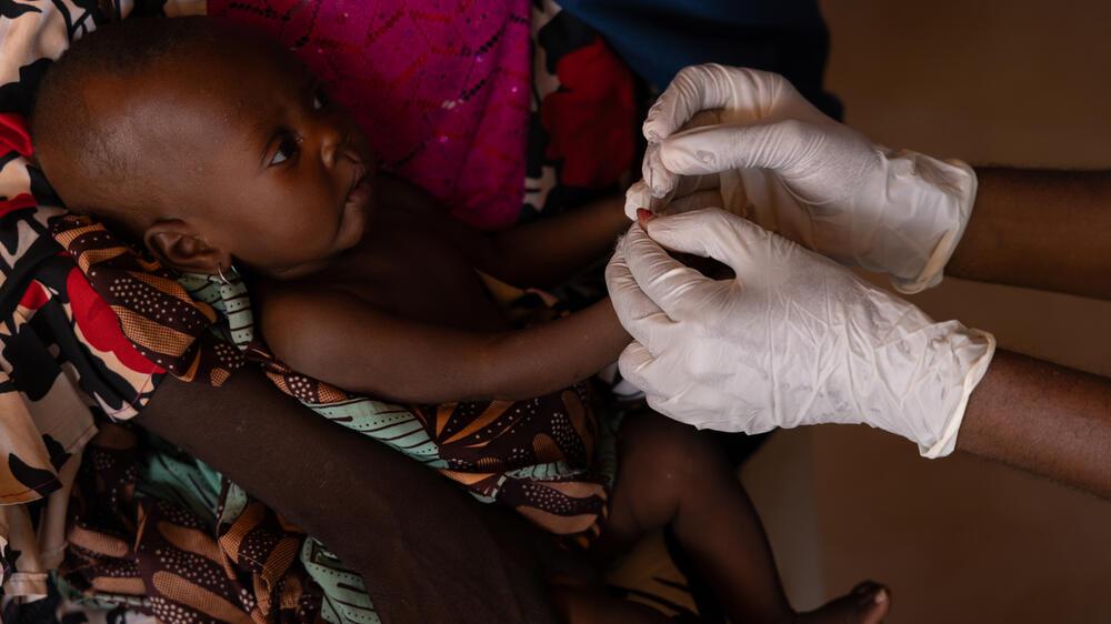 Nurse uses the mid-upper-arm circumference, a colour-coded band that is put around the upper arm to help determine if the child is malnourished or not. 