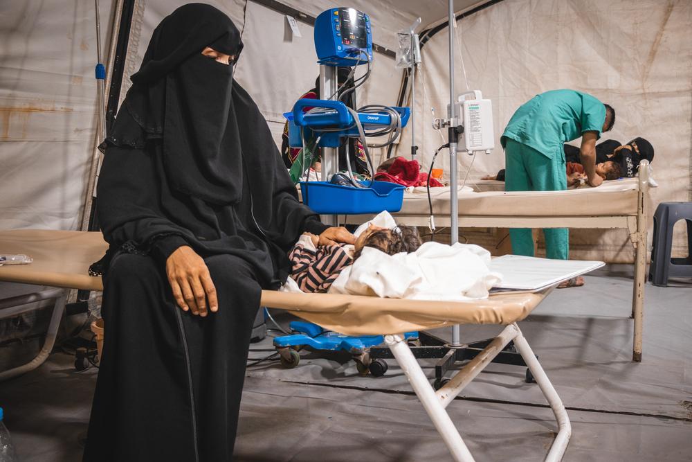 A mother sitting next to her child who is treated in cholera treatment centre. Yemen, May 2024. © Mario Fawaz/MSF