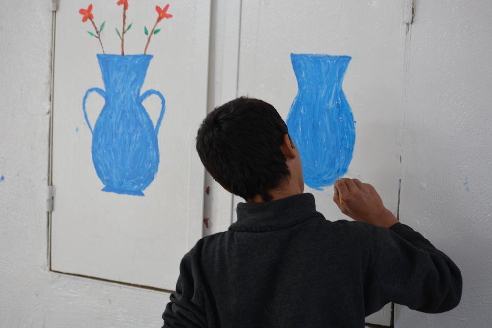 A teenager at an MSF mental health clinic drawing on the wall at Al-Hol camp, northeast Syria.