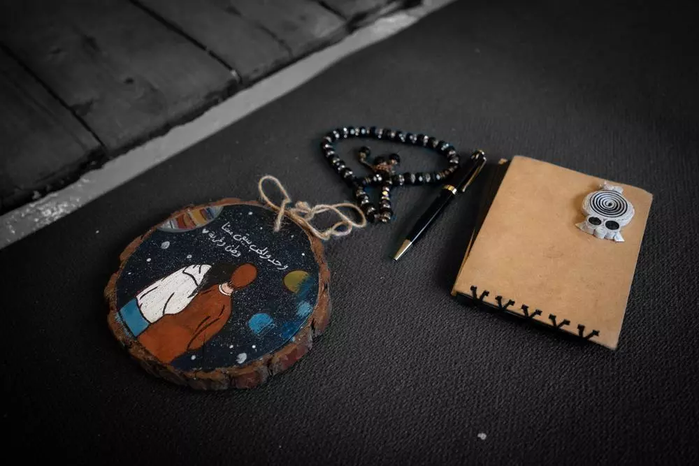 A wooden artwork with a writing in Arabic which translated to: Only love keeps us at home and abroad.