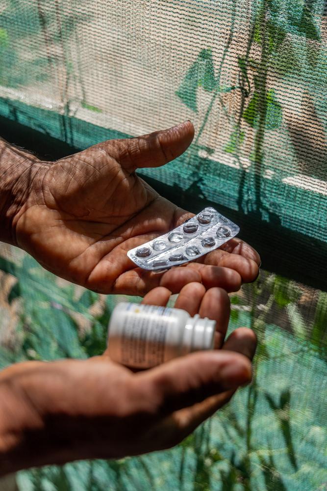 A Syrian refugee in Lebanon holds his empty hypertension medication.