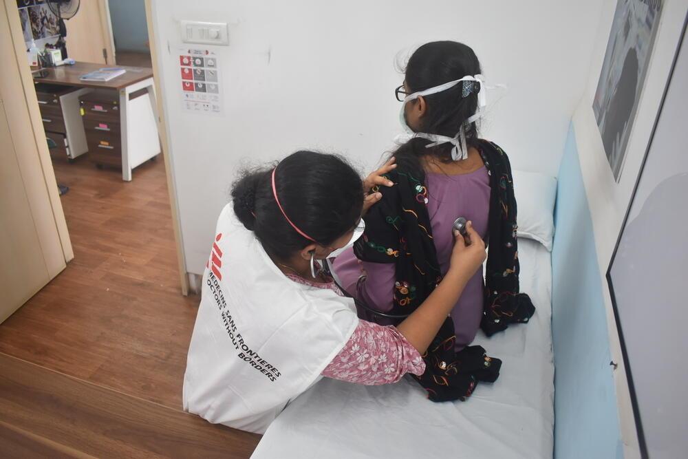 A physical examination of a patient with drug-resistant tuberculosis during her follow-up visit to end TB clinic.