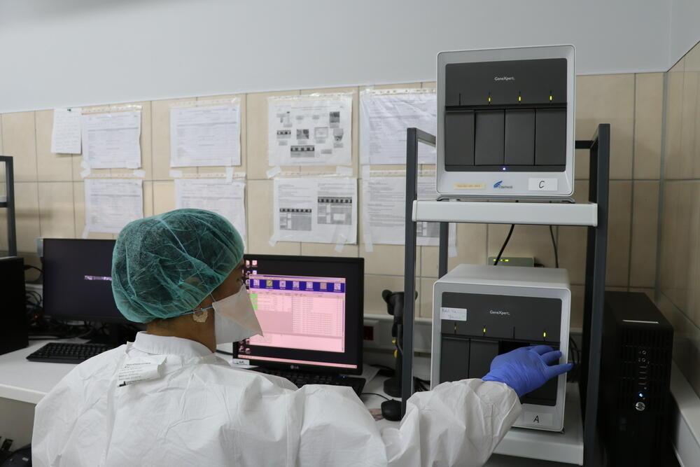 An MSF lab technician installs TB cartridges in the GeneXpert machine to test for TB. 