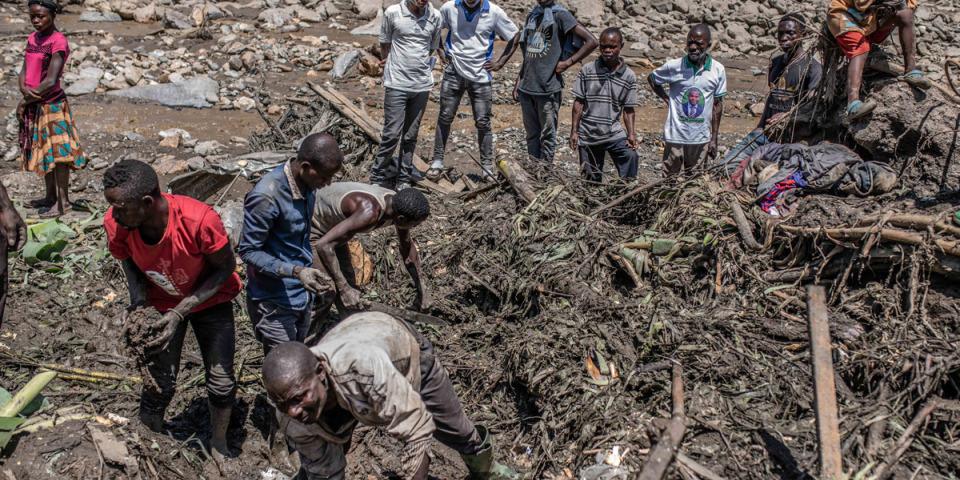 A group of people searches through the rubbles for bodies washed away by floods in Bushuhsu, Kalehe.