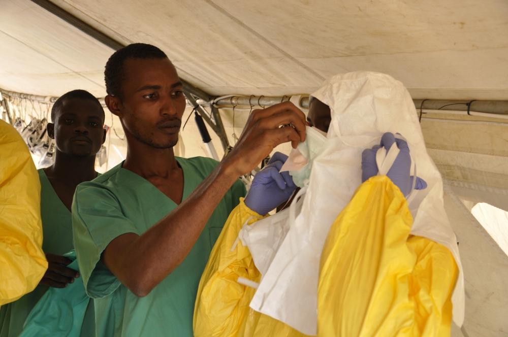 Members of the medical team are getting fully dressed with protective clothing prior to entering the ebola healthcare structure.