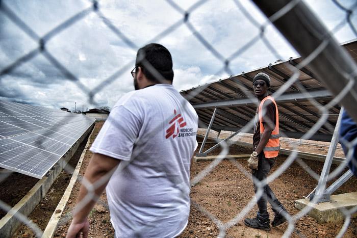  MSF supply manager Gerardo Rivera and logistics supervisor Mohammed Korma check the solar panels that partially power Hangha hospital in Kenema district