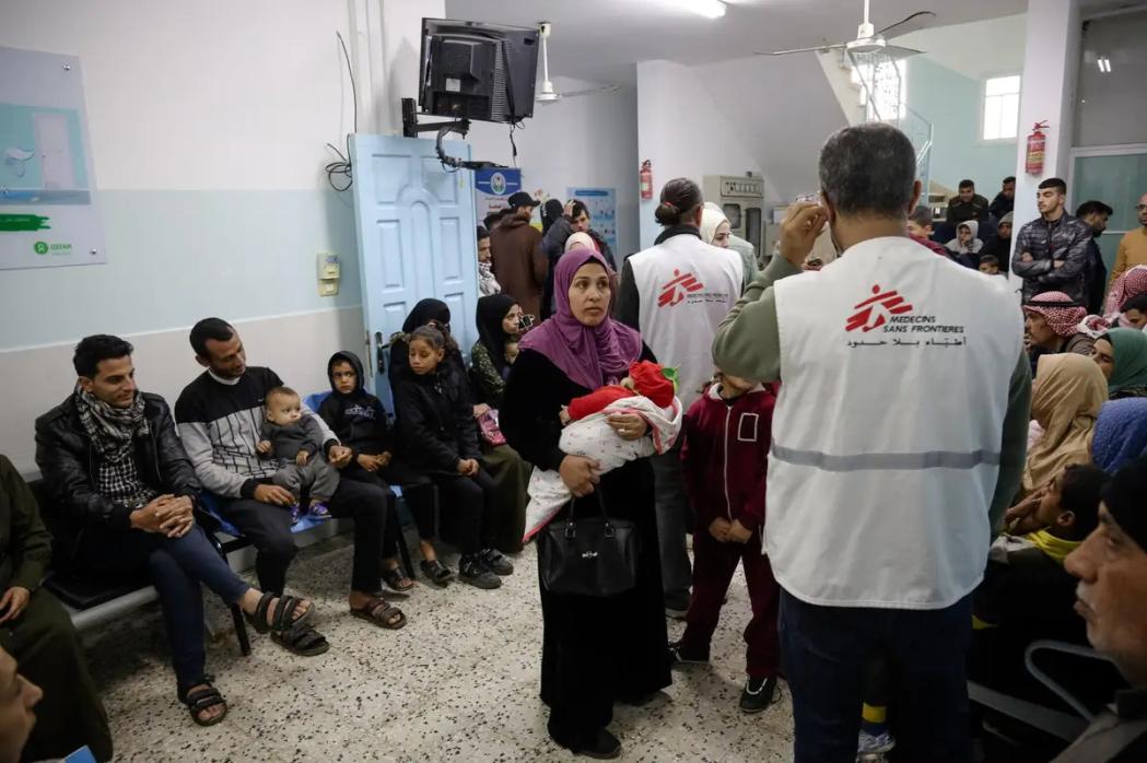 MSF health workers attends to families and children in an overcrowded waiting area at Al-Shaboura clinic, in Rafah,