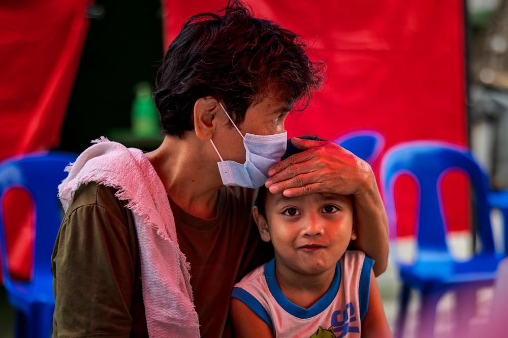 A grandmother with her grandson at one of MSF's active case finding sites for tuberculosis on March 13, 2023 in Tondo, Manila.