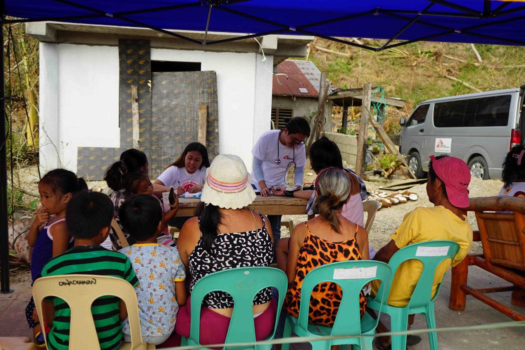 Nurse Briccio Echo Jr. works with a local nurse to triage patients at the mobile clinic. 