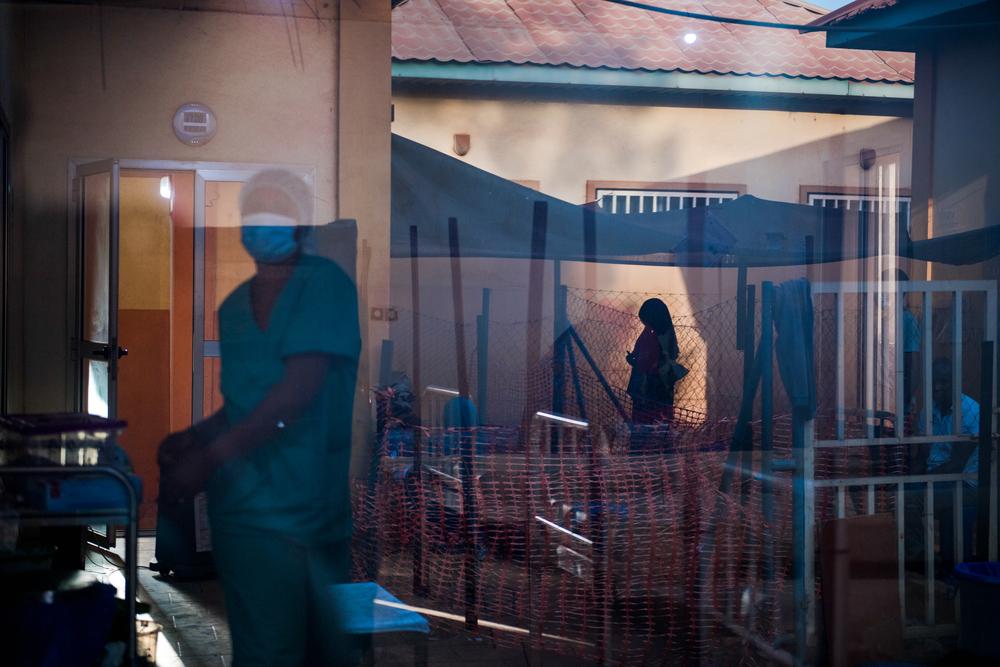 A nurse walks among patients at the Centre de Traitement Epidemiologique in Siguiri, Guinea,