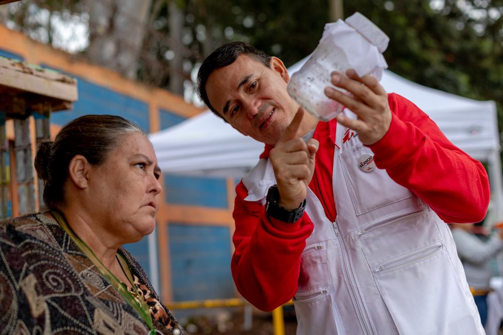 Fighting dengue with mosquitoes Teresa Arteaga is a neighbor of colonia Canaán. Here she curiously observes the Wolbachia-carrying mosquitoes that will be released in her community.