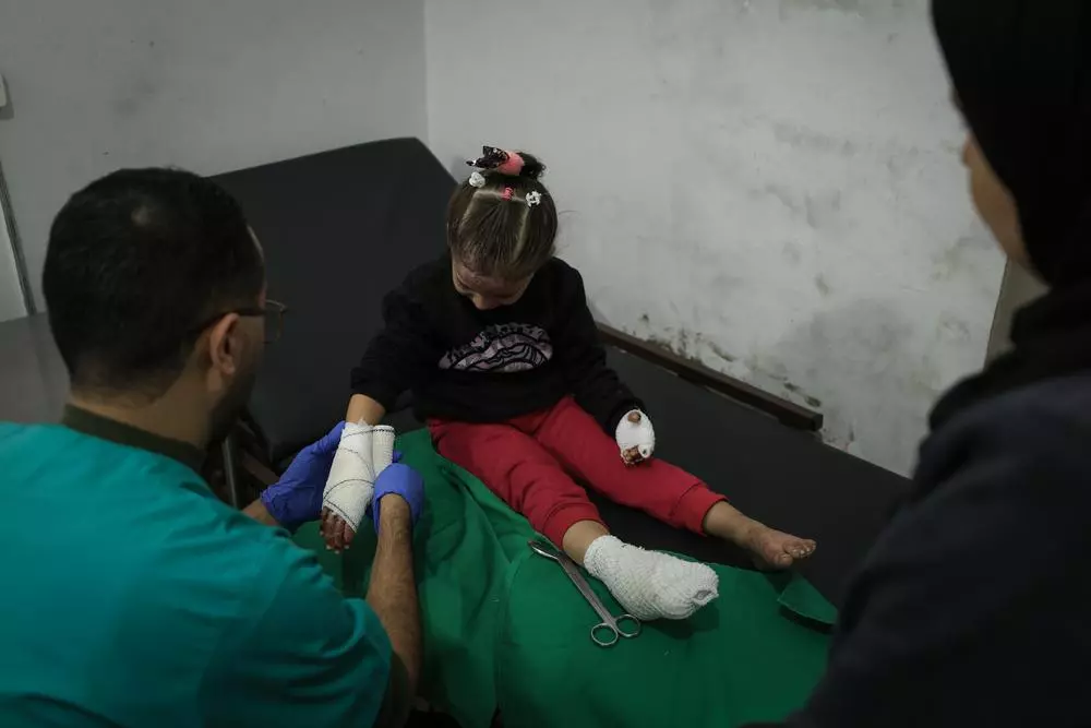 Doctors Without Borders nurse is tending to a girl's burn injuries at the clinic in Gaza City.