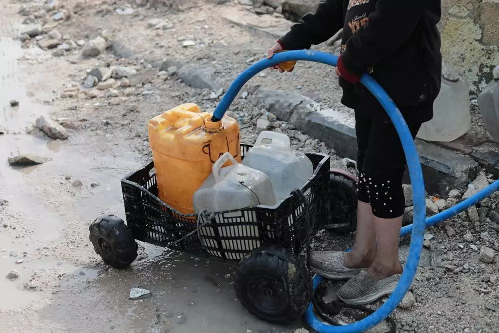 Palestinian child is collecting water in Beit Lahia city, north of Gaza strip