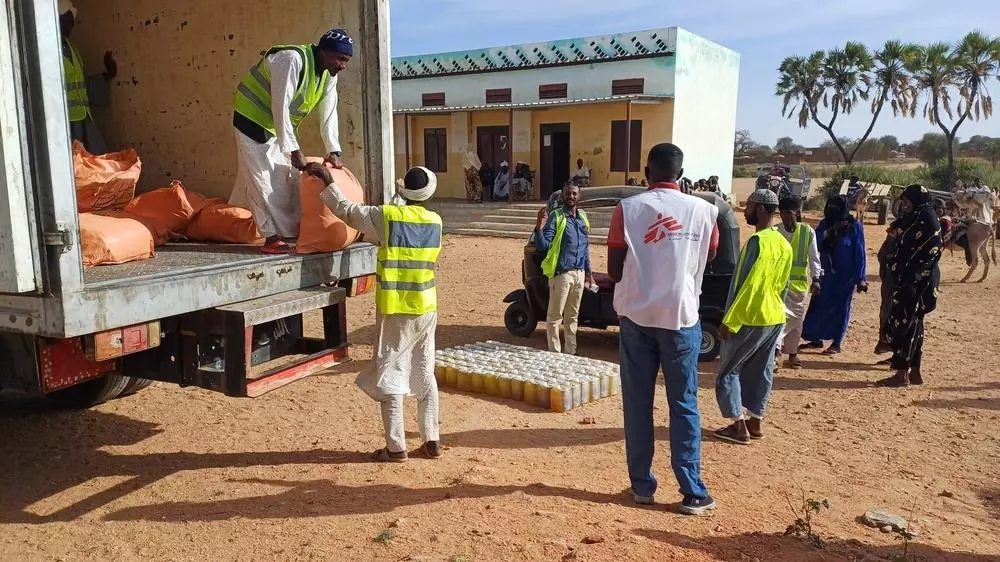 MSF staff offloading the truck to prepare for the distribution in outskirts of Nyala, South Darfur.