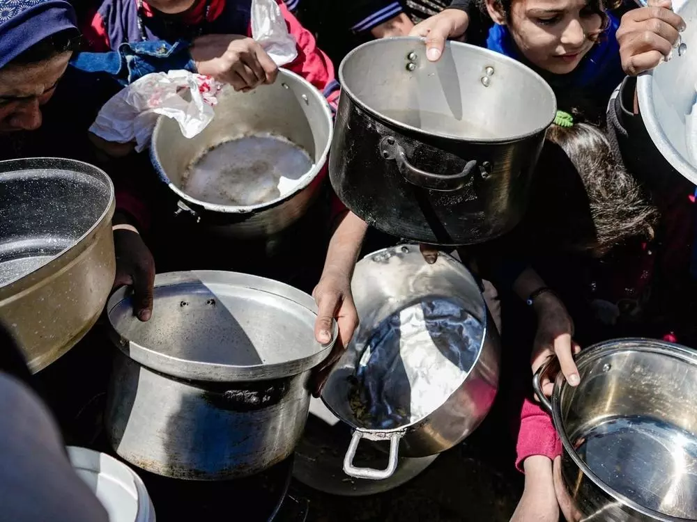 Kids holding their empty pots at a community kitchen in Northern Gaza.