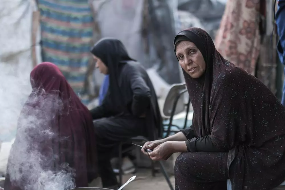 A woman cooks over open flame