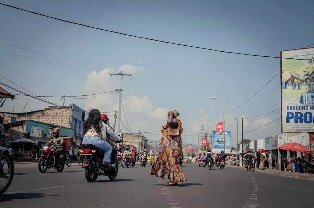 A woman stands by a busy road