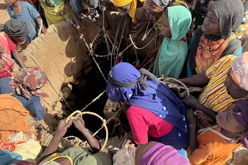 People taking water from a well