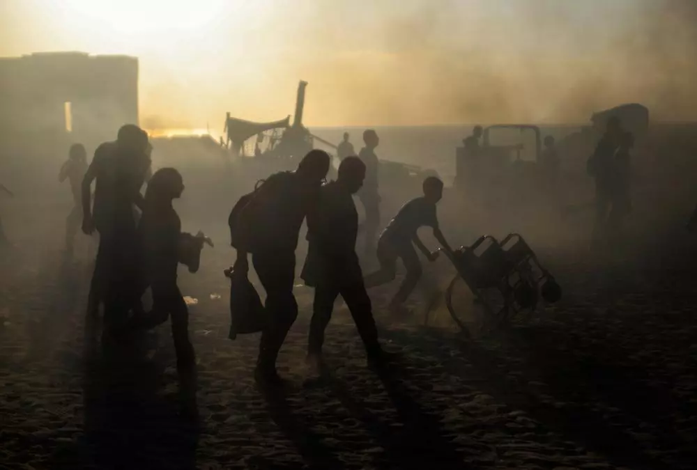 Silhouettes of Palestinians at a GHF aid distribution site