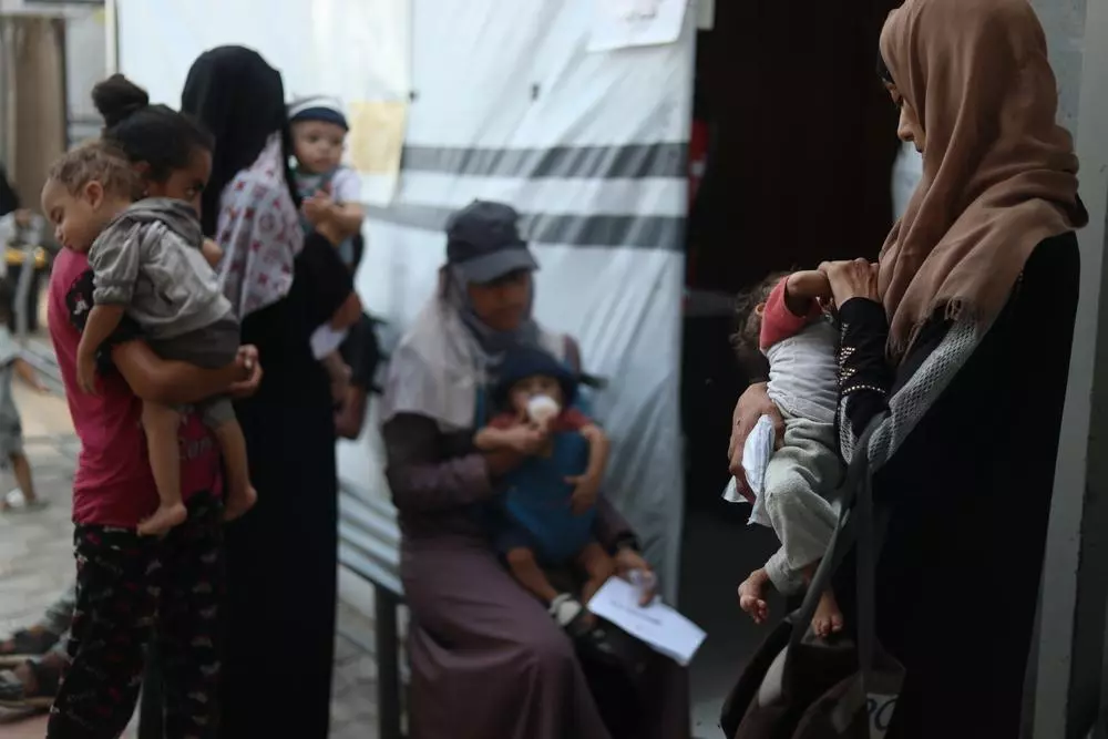 Mothers holding their severely malnourished babies wait to see medical staff at MSF’s Attar clinic in Khan Younis