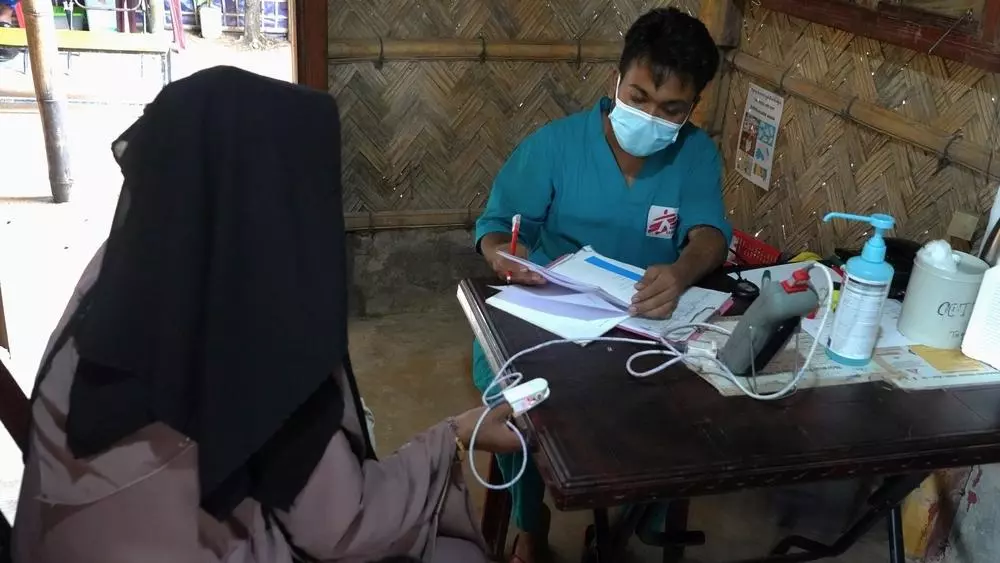 MSF staff performing triage on patient