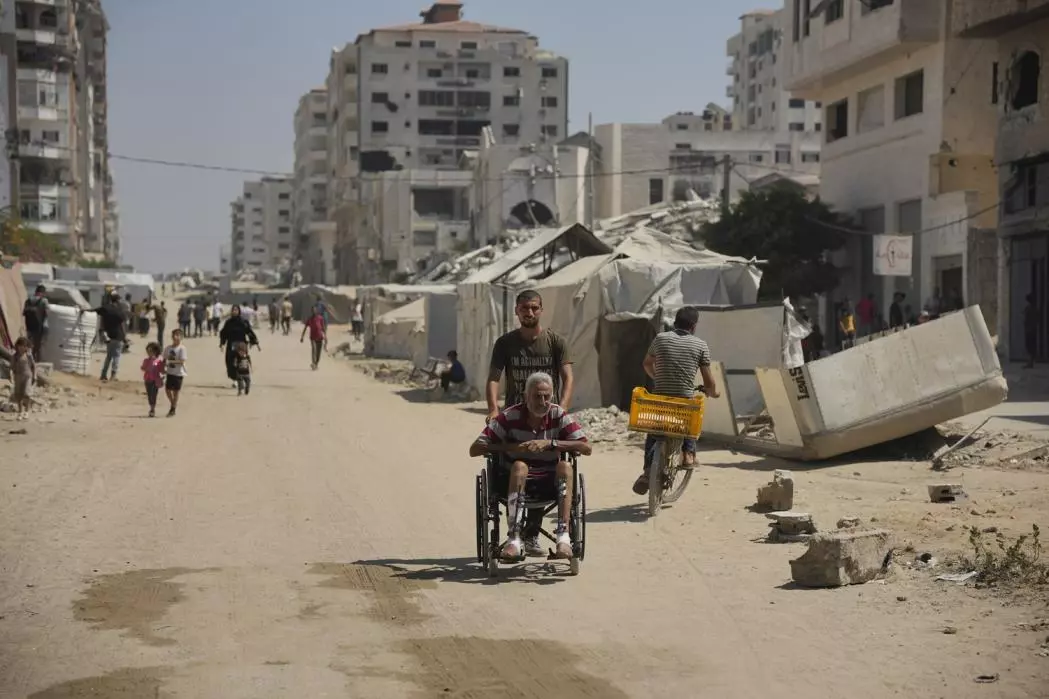 Man pushing older man in a wheelchair