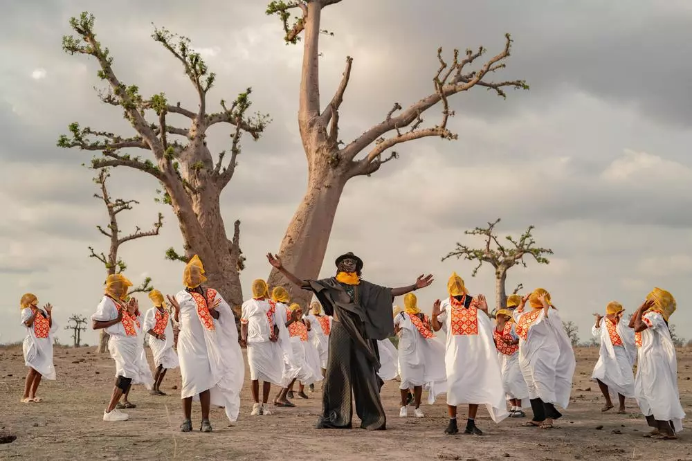 Mao Sidibé (center, in black) perfoms with dancers from the École des Sables dance company under a baobab tree in Sindia