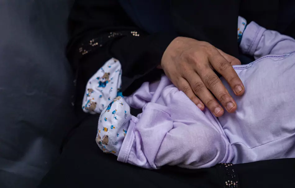Hand holding infant