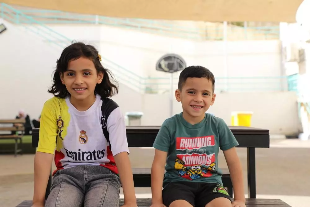 Two children sitting and smiling