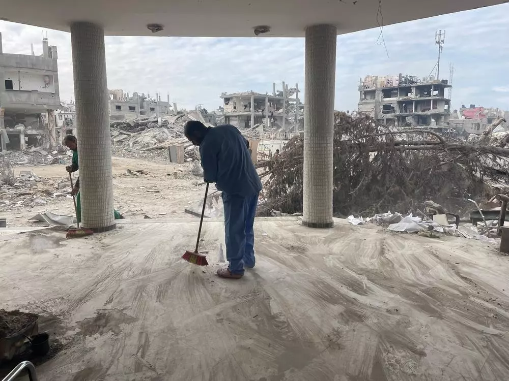 Men clean out the rubble inside the Emirati hospital in Rafah.