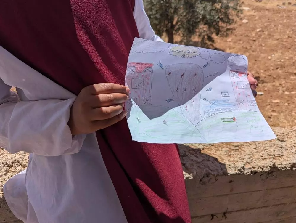 A child holding a drawing