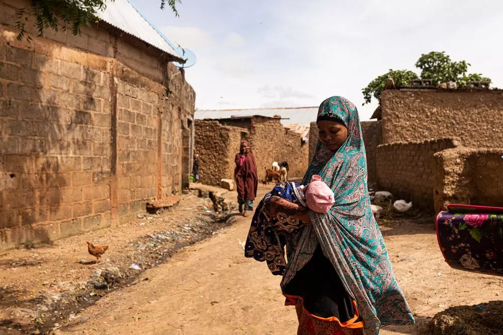 A new mother,reaches her home while carrying her baby