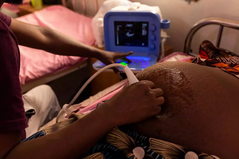A doctor performs an ultrasound on patient in pre-natal ward