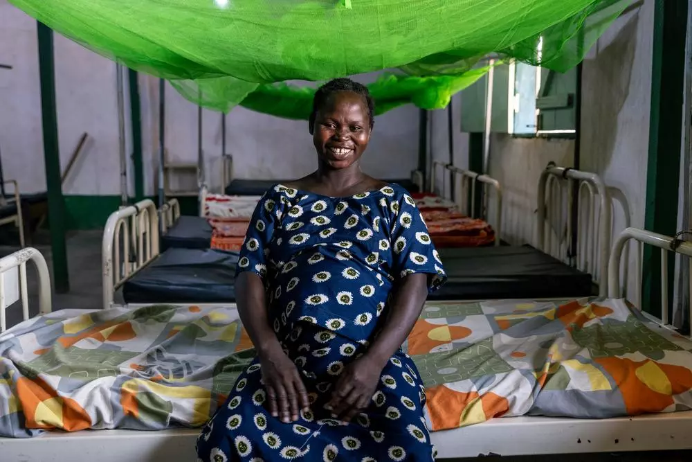 A pregnant mother sitting on a hospital bed