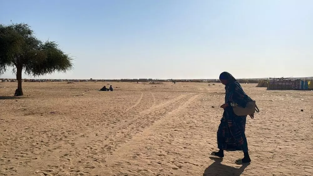 A woman walks through Daba Naira camp for internally displaced people in Tawila