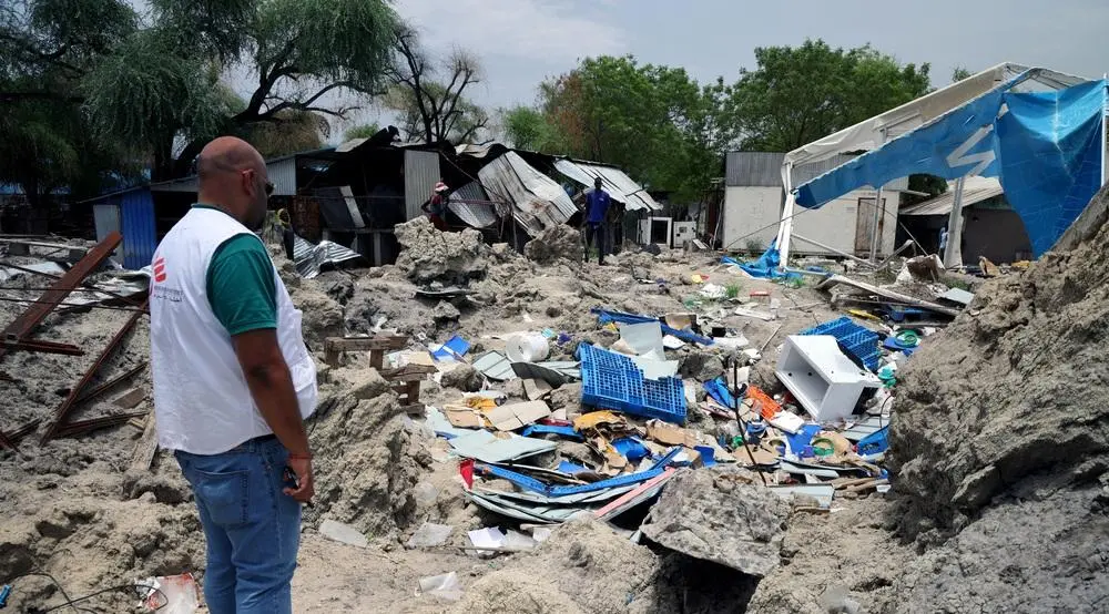 MSF HOM in front of bombarded warehouse