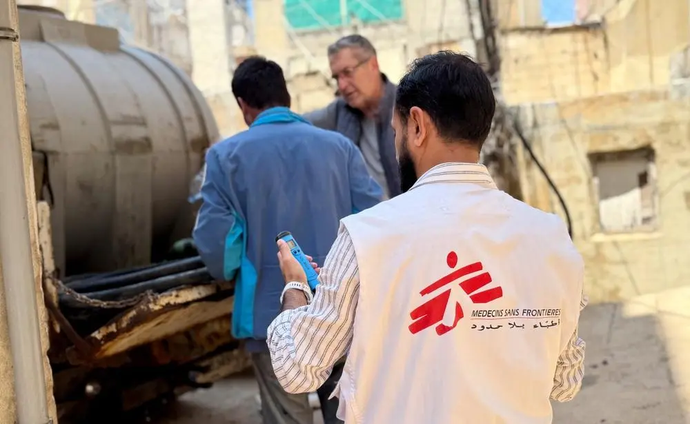 MSF WATSAN team leader checking water level